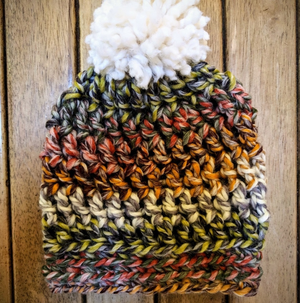 Hat in dark rainbow tones with fluffy cream pom!